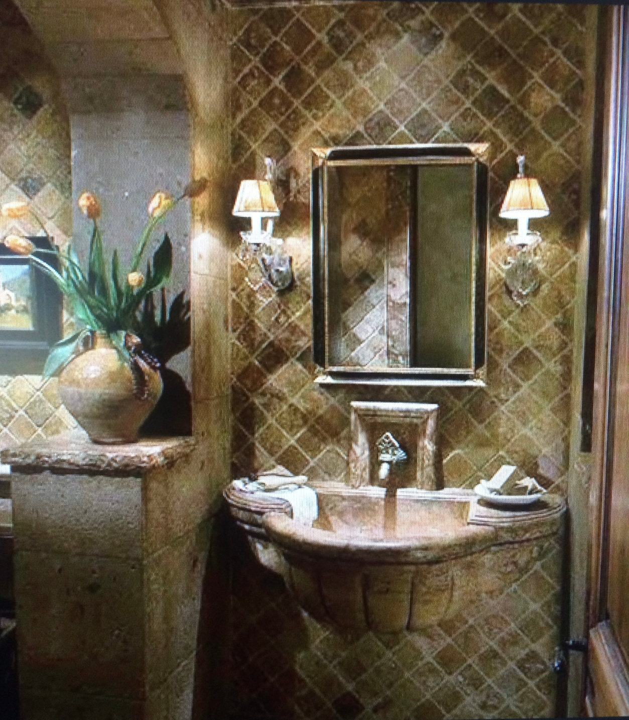 a bathroom with a sink, mirror and a vase of flowers melbourne fl granite countertops